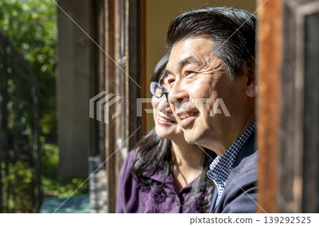 A smiling senior couple relaxing on the veranda of an old Japanese house. 139292525