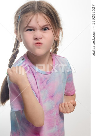 Young girl with braids making a defiant face, showing determination. Young girl with braids making a defiant face, showing determination. 139292527
