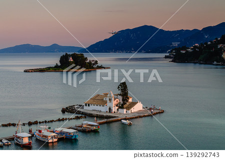 Typical view of Vlacherna Monastery and Mouse island with airplane landing, Corfu, Greece Typical view of Vlacherna Monastery and Mouse island with airplane landing, Corfu, Greece 139292743