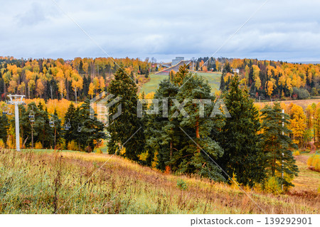 Ski resort landscape showcasing beautiful autumn foliage and ski lifts in the distance 139292901