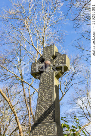 Ancient stone Celtic cross against a blue sky 139293091