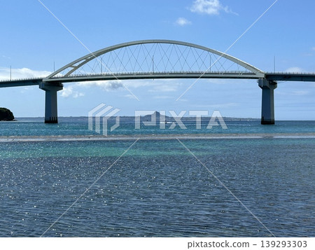 The scenery of Sesoko Bridge and Ie Island reflected on the sparkling surface of the sea. The scenery of Sesoko Bridge and Ie Island reflected on the sparkling surface of the sea. 139293303