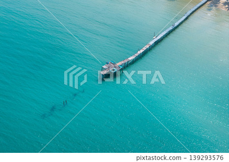 Long wooden pier stretching into the turquoise ocean at a luxury resort, Eastern Sea of Thailand. Long wooden pier stretching into the turquoise ocean at a luxury resort, Eastern Sea of Thailand. 139293576