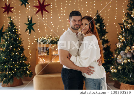 Couple standing in the Christmas style decorated room, conception of holidays and family Couple standing in the Christmas style decorated room, conception of holidays and family 139293589