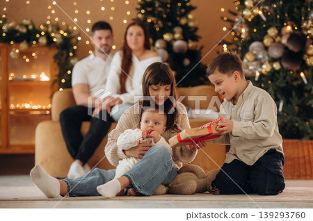The kids are playing. Happy family is celebrating the Christmas in the holidays decorated room The kids are playing. Happy family is celebrating the Christmas in the holidays decorated room 139293760