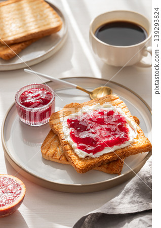 Toast with sweet berry-fruit jam and cream cheese on a plate on a white wooden background Toast with sweet berry-fruit jam and cream cheese on a plate on a white wooden background 139293824
