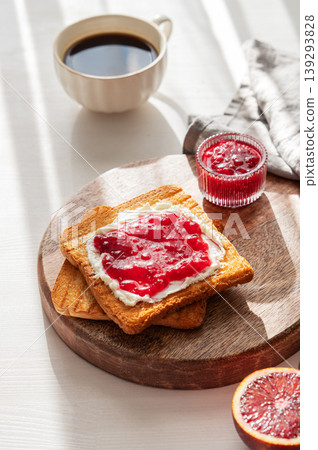 Toast with sweet berry-fruit jam and cream cheese on a wooden board on a white background 139293828