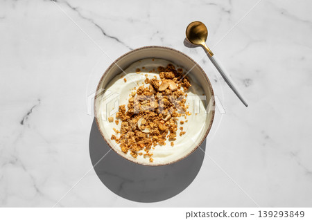 Balanced breakfast with yogurt, granola and spoon on marble background. Top view Balanced breakfast with yogurt, granola and spoon on marble background. Top view 139293849