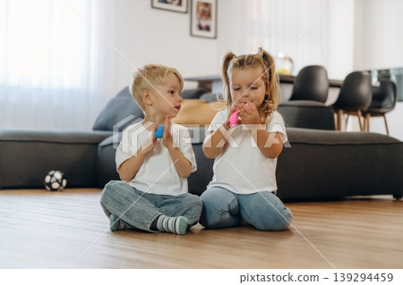 Plasticine in hands. Little kids are playing together in the domestic room at daytime 139294459