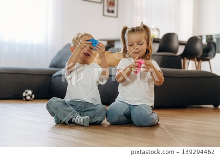 Plasticine in hands. Little kids are playing together in the domestic room at daytime 139294462