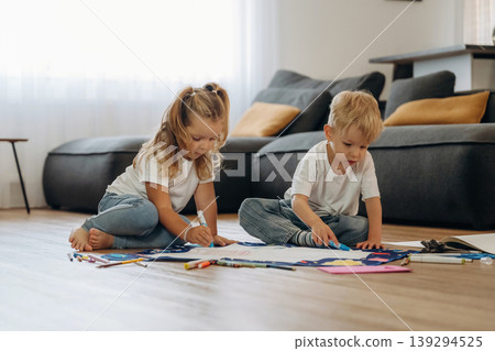 Markers and drawing board. Little kids are playing together in the domestic room at daytime 139294525