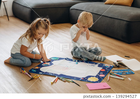 Markers and drawing board. Little kids are playing together in the domestic room at daytime Markers and drawing board. Little kids are playing together in the domestic room at daytime 139294527