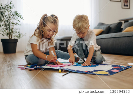 Many of the markers, drawing. Little kids are playing together in the domestic room at daytime Many of the markers, drawing. Little kids are playing together in the domestic room at daytime 139294533