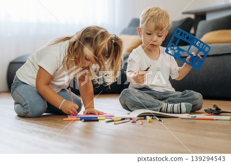 Imagination concept, drawing. Little kids are playing together in the domestic room at daytime Imagination concept, drawing. Little kids are playing together in the domestic room at daytime 139294543