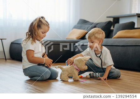 Doctors with stethoscope and toy. Little kids are playing together in the domestic room at daytime 139294554