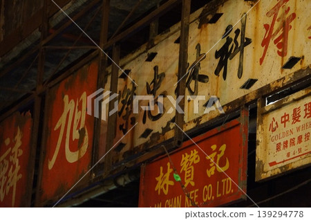 破敗的街景,鏽跡斑斑的漢字招牌在裸露的燈泡下閃爍。 破敗的街景,鏽跡斑斑的漢字招牌在裸露的燈泡下閃爍。 139294778
