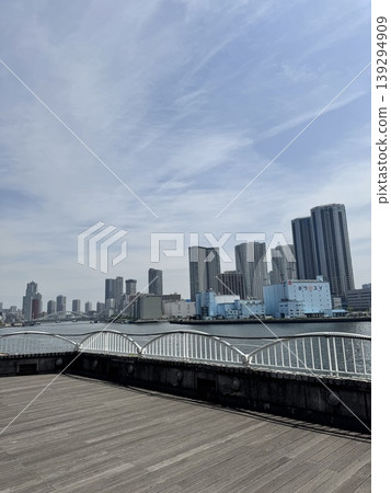 竹芝地區的現代建築和蔚藍的天空。從木製平台上眺望東京海灣的城市景觀。 竹芝地區的現代建築和蔚藍的天空。從木製平台上眺望東京海灣的城市景觀。 139294909