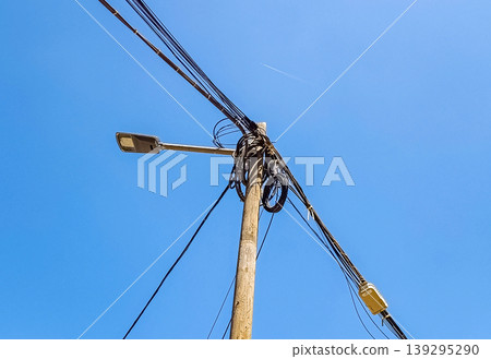 Wooden Street Lamp with Multiple Cables Under Blue Sky 139295290