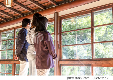 A family trip enjoying the scenery from the veranda of a traditional Japanese house. A family trip enjoying the scenery from the veranda of a traditional Japanese house. 139295570