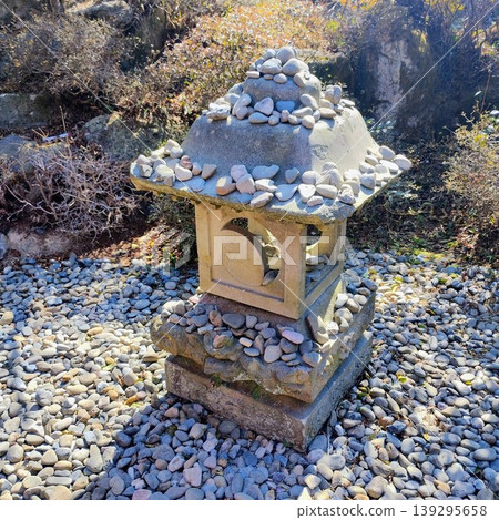 A stone lantern standing in a winter garden A stone lantern standing in a winter garden 139295658