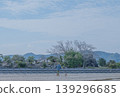 A couple walking on the beach with their dog, seen from behind. A natural scene of everyday life and a stroll along the seaside. 139296685