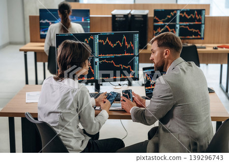Men are sitting and talking. Business people are working with stock market exchange in office Men are sitting and talking. Business people are working with stock market exchange in office 139296743
