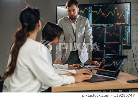 Using laptop and computer, side view. Business people are working with stock market exchange in office 139296747