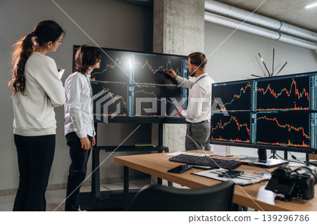 Big screen, showing data. Business people are working with stock market exchange in office Big screen, showing data. Business people are working with stock market exchange in office 139296786