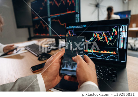 Close up view of hands of business men that are working with stock market exchange Close up view of hands of business men that are working with stock market exchange 139296831