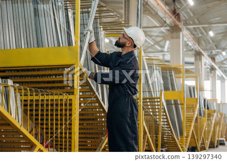 Bunch of raw windows parts. Warehouse worker in an industrial environment of a factory or storage area Bunch of raw windows parts. Warehouse worker in an industrial environment of a factory or storage area 139297340