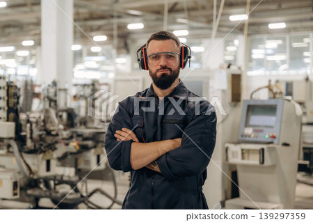 In protective headphones. Warehouse worker in an industrial environment of a factory or storage area In protective headphones. Warehouse worker in an industrial environment of a factory or storage area 139297359
