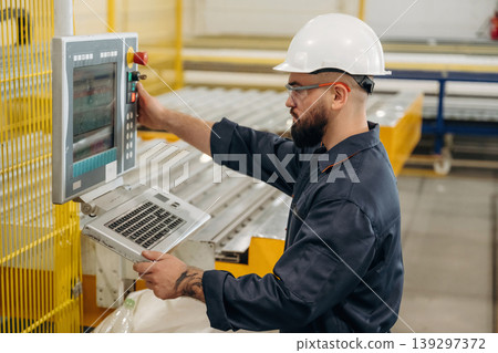 Busy machine operator. Warehouse worker in an industrial environment of a factory or storage area Busy machine operator. Warehouse worker in an industrial environment of a factory or storage area 139297372