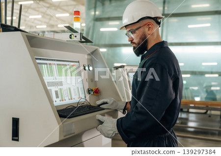 Looking at display of machine, operator is working. Warehouse worker in an industrial environment of a factory or storage area Looking at display of machine, operator is working. Warehouse worker in an industrial environment of a factory or storage area 139297384