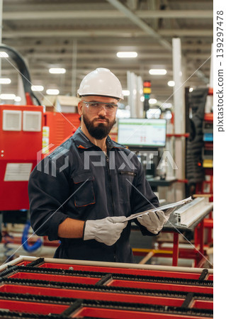 Notepad with document is in hands. Warehouse worker in an industrial environment of a factory or storage area Notepad with document is in hands. Warehouse worker in an industrial environment of a factory or storage area 139297478