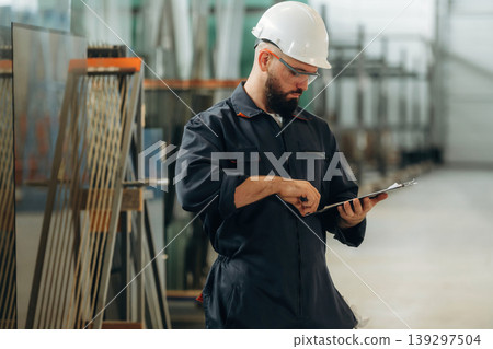 Warehouse worker in an industrial environment of a factory or storage area Warehouse worker in an industrial environment of a factory or storage area 139297504