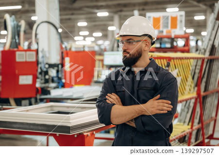 Break time, standing with arms crossed. Warehouse worker in an industrial environment of a factory or storage area Break time, standing with arms crossed. Warehouse worker in an industrial environment of a factory or storage area 139297507