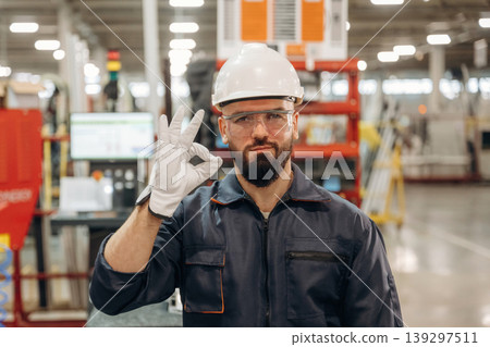 Everything is under control, showing hand gesture. Warehouse worker in an industrial environment of a factory or storage area Everything is under control, showing hand gesture. Warehouse worker in an industrial environment of a factory or storage area 139297511