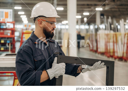 Checking quality of small window border. Warehouse worker in an industrial environment of a factory or storage area 139297532