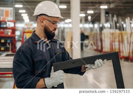 Checking quality of small window border. Warehouse worker in an industrial environment of a factory or storage area Checking quality of small window border. Warehouse worker in an industrial environment of a factory or storage area 139297533