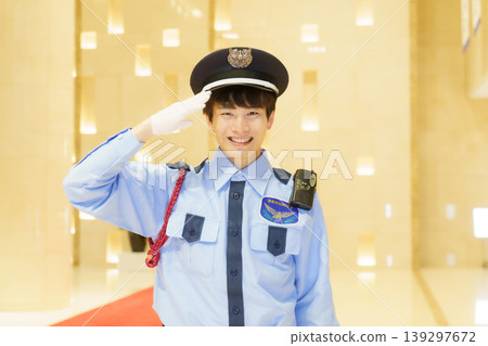 A young Japanese male security guard salutes. Photo courtesy of Denpa Gakuen Educational Foundation, Tokyo Electronics College. A young Japanese male security guard salutes. Photo courtesy of Denpa Gakuen Educational Foundation, Tokyo Electronics College. 139297672