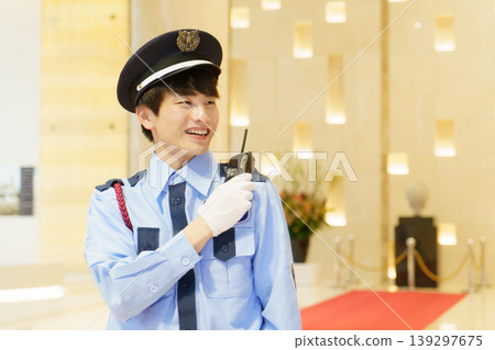 一名年輕的日本保全正在使用對講機通話。照片由東京電子學院電波學園教育基金會提供。 一名年輕的日本保全正在使用對講機通話。照片由東京電子學院電波學園教育基金會提供。 139297675
