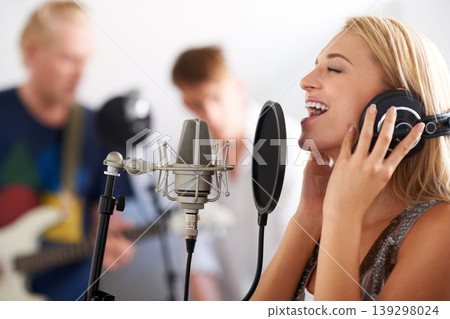 Music, performance and woman with microphone, headphones and singing band with talent. Recording studio, art and happy girl musician live streaming song for record label, sound and audio broadcast. Music, performance and woman with microphone, headphones and singing band with talent. Recording studio, art and happy girl musician live streaming song for record label, sound and audio broadcast. 139298024