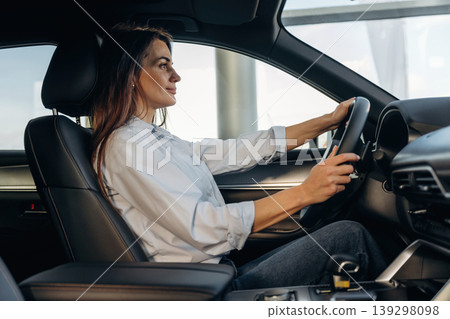 Driving, comfortable seat. Woman is sitting in the modern car, happy new owner Driving, comfortable seat. Woman is sitting in the modern car, happy new owner 139298098