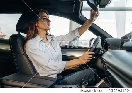 Driving, comfortable seat. Woman is sitting in the modern car, happy new owner Driving, comfortable seat. Woman is sitting in the modern car, happy new owner 139298100