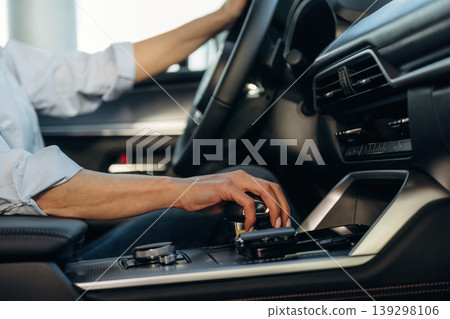 Using the control panel. Detailed close up view of woman that is driving the new car 139298106
