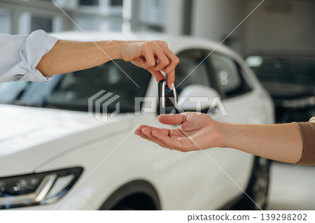 Close up view of woman's and man's hands that are taking the keys for new car Close up view of woman's and man's hands that are taking the keys for new car 139298202