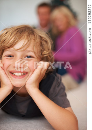 Portrait, boy and relaxing with parents for holiday, happy and excited on floor. Bonding together, smile and family home for festive season, cheerful and joy in house, childhood memories or indoor 139298262