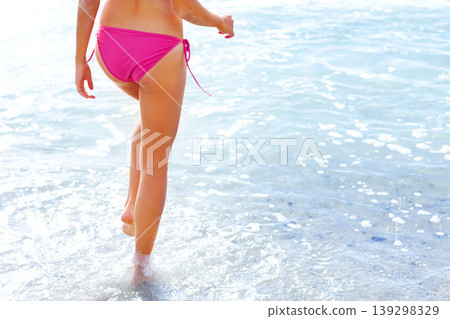 Walking, legs and woman in bikini on beach for summer vacation, travel adventure and tropical island. Relax, waves and girl at calm ocean for holiday with sunshine and nature and freedom in Hawaii. 139298329