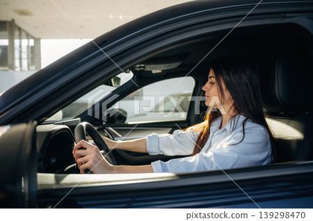 Woman is sitting in the modern car, happy new owner Woman is sitting in the modern car, happy new owner 139298470