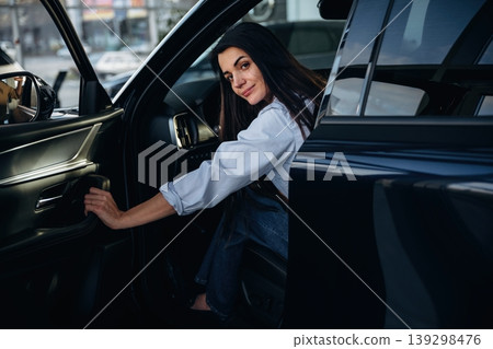 Closing the door. Woman is sitting in the modern car, happy new owner 139298476